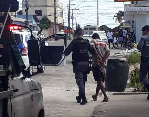 Cena da manhã: Populares observam indivíduo algemado a caminho de viatura da PM