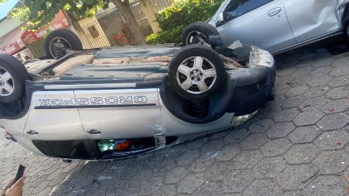 Crossfox bate em carro estacionado e capota no Conceição
