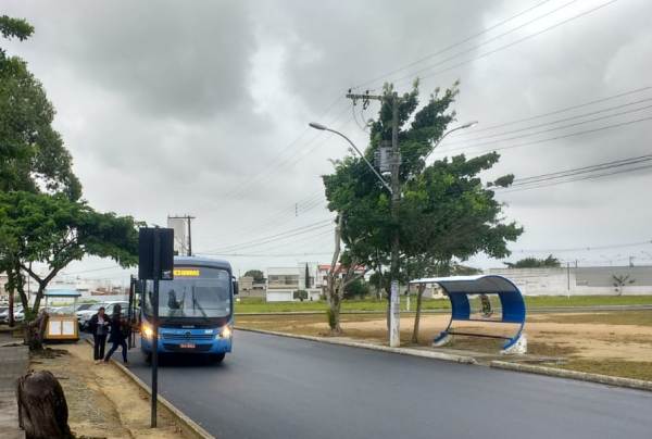 Abrigo de um lado, passageiros do outro, em frente ao Fórum de Linhares