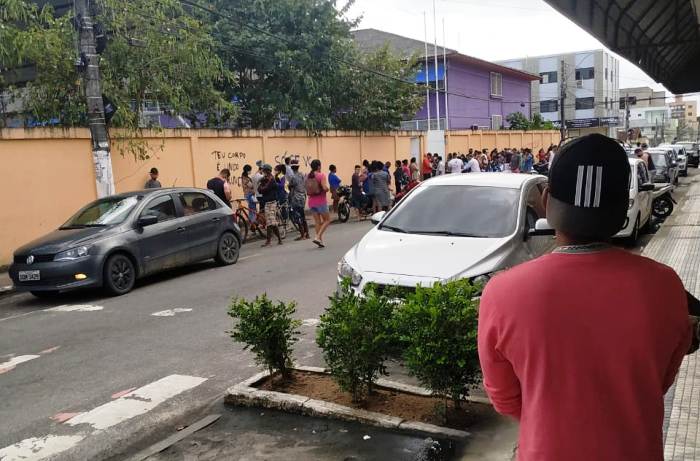 Auxílio Emergencial: Homem observa fila na calçada do Bartouvino Costa, em Linhares
