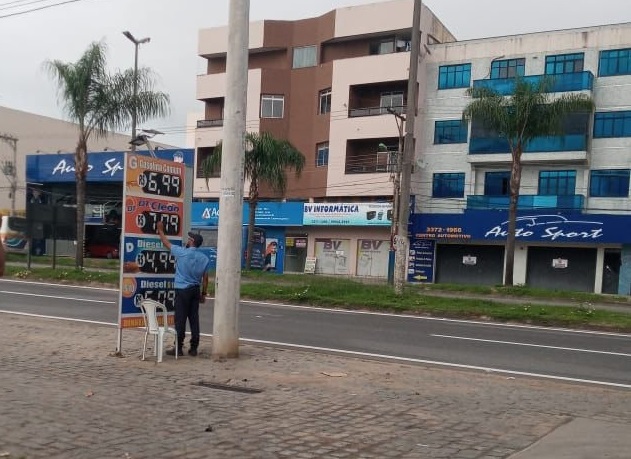 Reajuste da gasolina: Cena mostra homem alterando os preços em placa de posto em Linhares