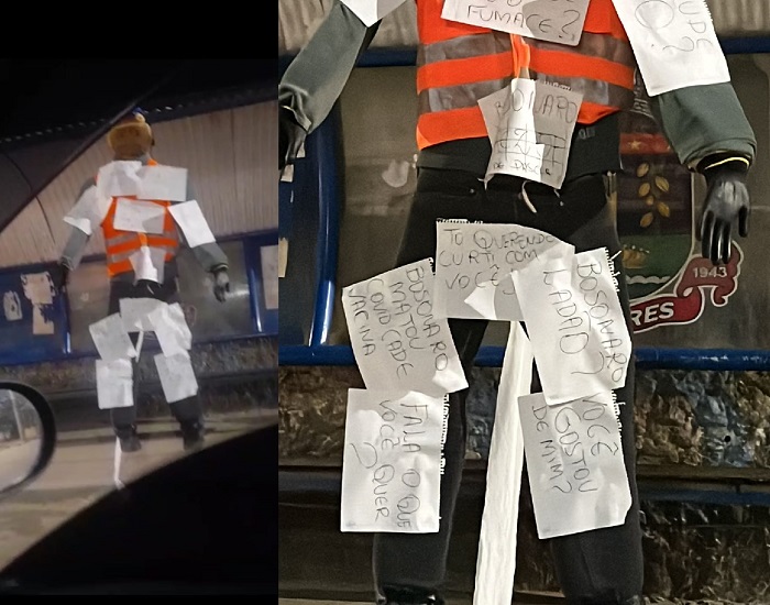 Boneco cheio de cartazes chama a atenção em ponto de ônibus de Linhares