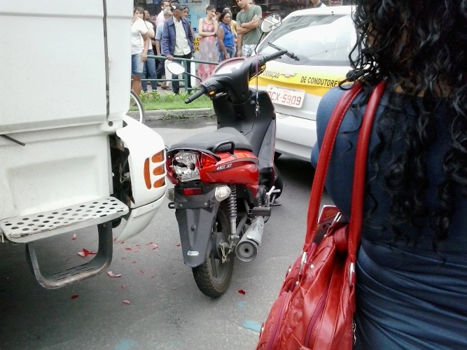 Centro: moto fica prensada entre caminhão e carro de autoescola